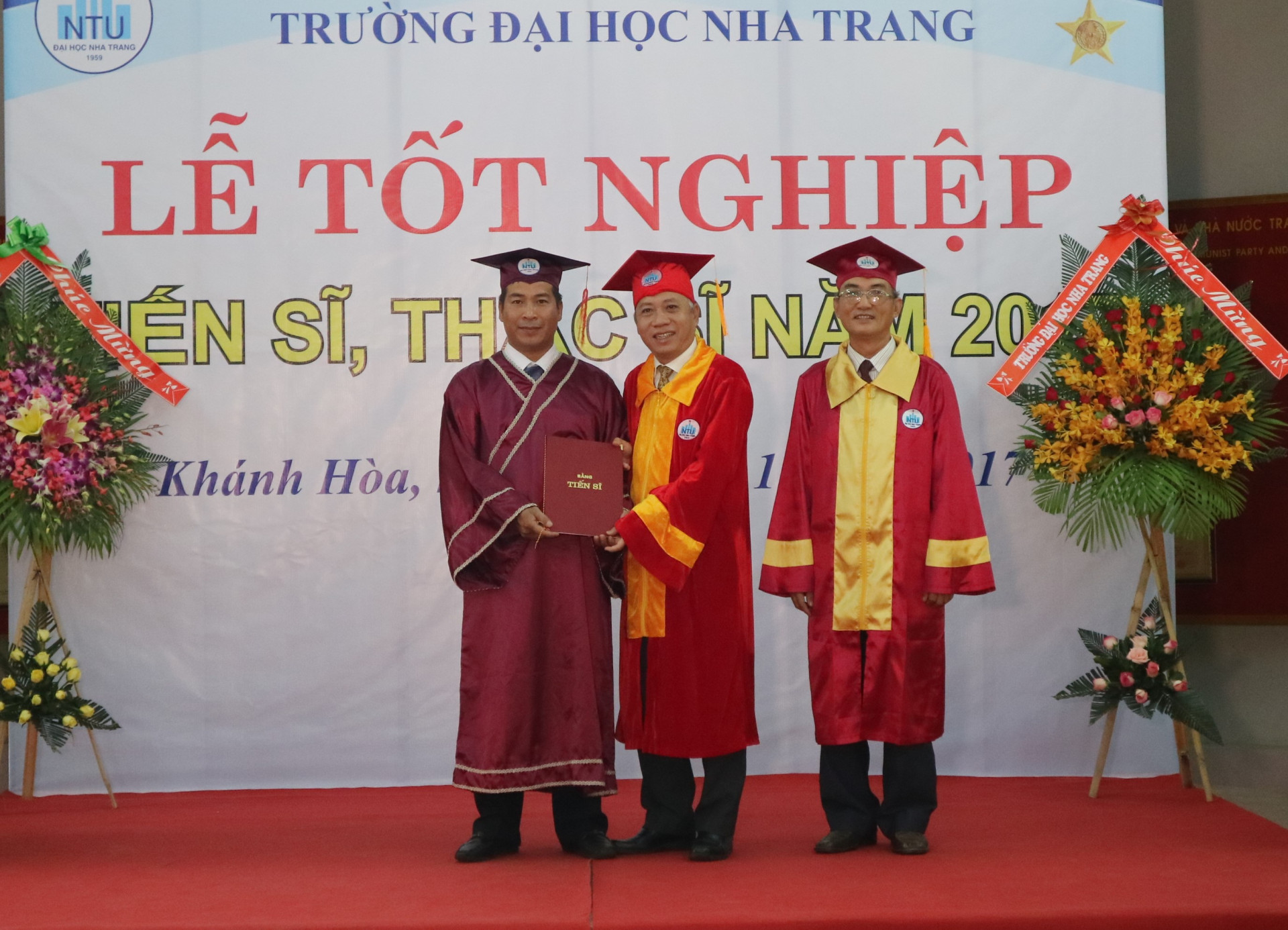 Lãnh đạo Trường Đại học Nha Trang (giữa) trao bằng tiến sĩ cho học viên. 
