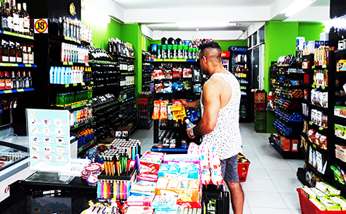 Một du khách đang mua hàng tại cửa hàng tiện lợi trên đường Nguyễn Thiện Thuật