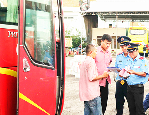 Lực lượng thanh tra giao thông kiểm tra các giấy tờ liên quan của tài xế một hãng xe khách