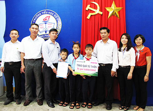 Lãnh đạo Báo Khánh Hòa và Vietcombank Nha Trang trao tượng trưng sổ tiết kiệm cho 3 chị em Trà My, Trung Thái, Trung Hiếu