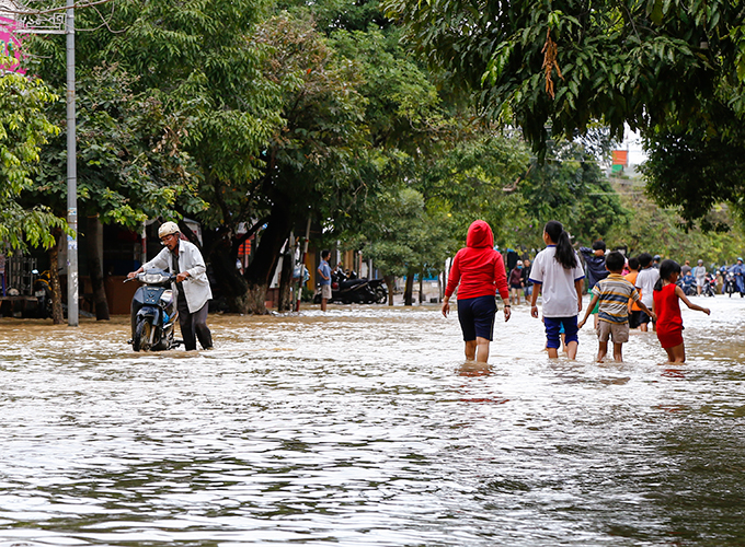 Người dân ở trung tâm thị xã Ninh Hòa bì bõm trong nước ngập.