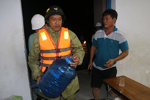 Lực lượng chức năng phường Cam Nghĩa cung cấp nước uống cho các công nhân tránh bão tại Trường THCS Nguyễn Văn Trỗi. 