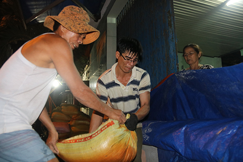  Một hộ dân ở phường Cam Nghĩa khẩn trương gia cố lại cửa nhà trong đêm 3-11, tránh bị nước lụt tràn vào nhà gây hư hỏng tài sản.