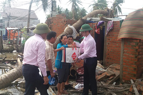 Ông Nguyễn Đức Hải - Phó Tổng Giám đốc NHCSXH trao tiền và quà hỗ trợ cho gia đình ông Trần Văn Bảy (tổ 14 thị trấn Vạn Giã) bị sập nhà. 