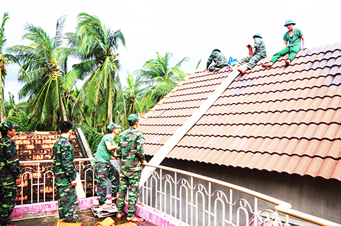 Cán bộ, chiến sĩ Đồn Biên phòng Vạn Hưng sửa mái nhà cho người dân