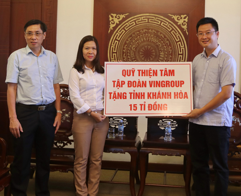 Đại diện Tập đoàn Vingroup (bên phải) trao 15 tỷ đồng ủng hộ đồng bào bị thiệt hại do bão cho lãnh đạo UBMTTQ Việt Nam tỉnh Khánh Hòa.     