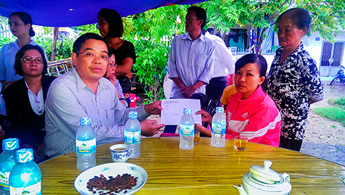 Ông Nguyễn Sỹ Khánh trao tiền hỗ trợ cho gia đình