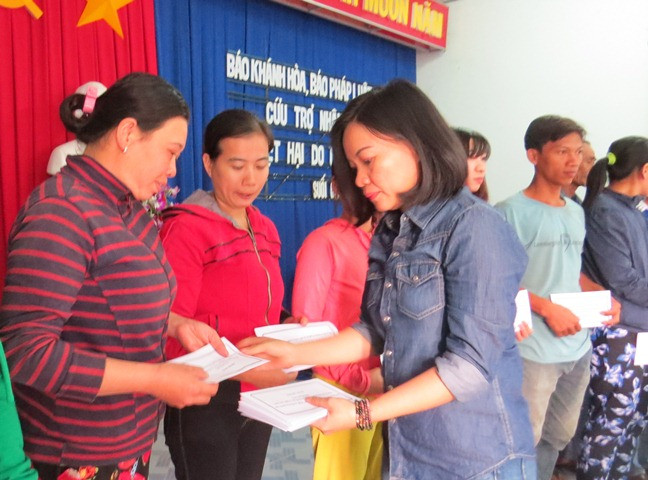Bà Thái Thị Lệ Hằng - Phó Tổng biên tập Báo Khánh Hòa trao quà cho người dân xã Suối Cát 
