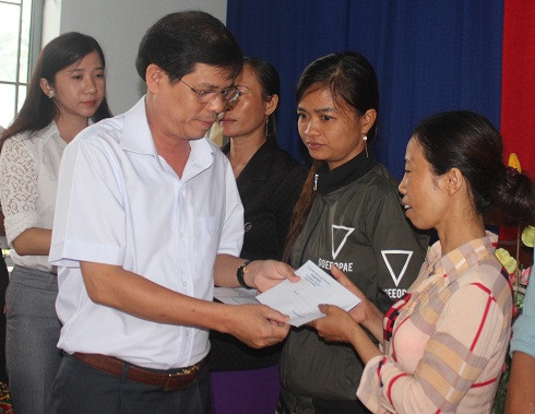Ông Nguyễn Tấn Tuân trao hỗ trợ cho người nghèo.