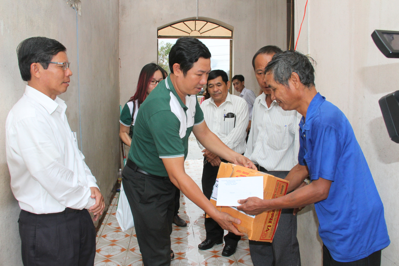 Ông Phan Ngọc Kính – Giám đốc Ngân hàng thương mại cổ phần  Ngoại thương chi nhánh Nha Trang trao quà cho các hộ dân bị thiệt hại bão 12.