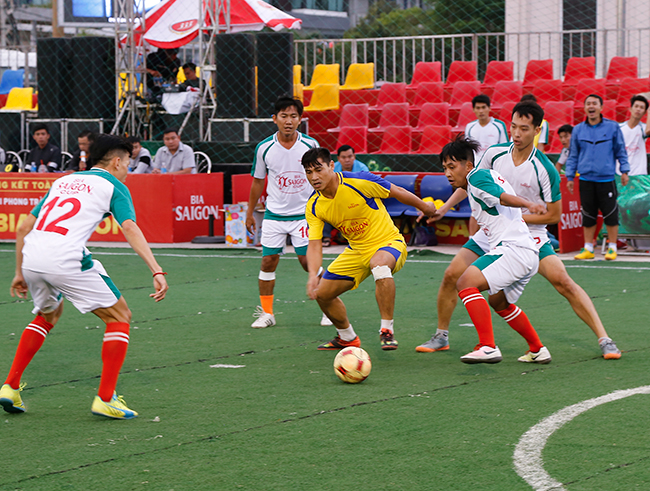 Dao Van Phong (yellow uniform) of Olympic Gym Khanh Hoa dueling for ball with opponents.