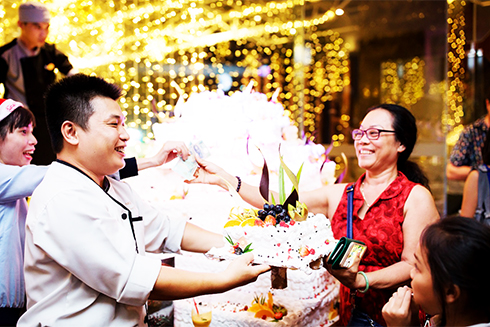 Guests buying Christmas cake for charity in Novotel Nha Trang
