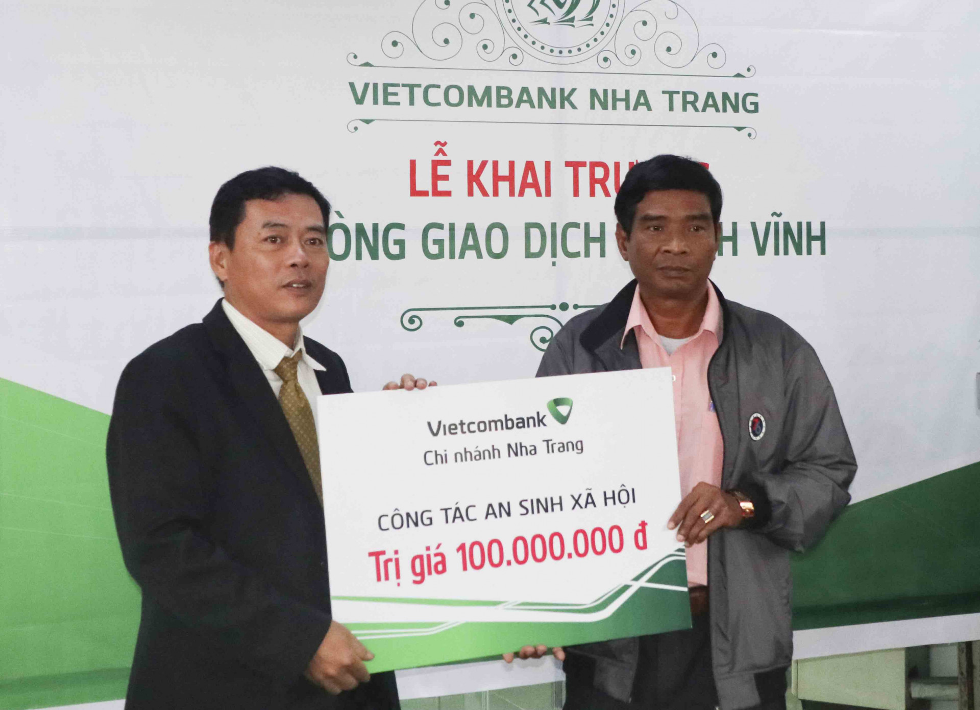 Đại diện UBMTTQ Việt Nam huyện Khánh Vĩnh (bìa phải) tiếp nhân hỗ trợ từ Vietcombank chi nhánh Nha Trang