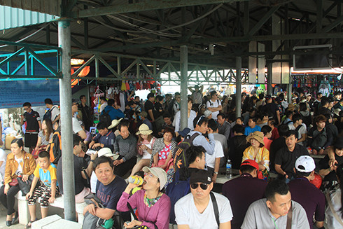 Hàng trăm du khách ngồi ở khu vực nhà chờ của Bến tàu du lịch Cầu Đá.