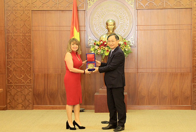 Nguyen Dac Tai offering souvenir gift to Paula Shugart