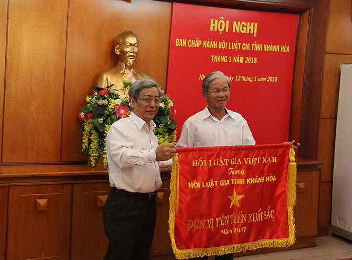 Ông Lê Xuân Thân trao cờ thi đua cho đại diện Hội Luật gia tỉnh Khánh Hòa.