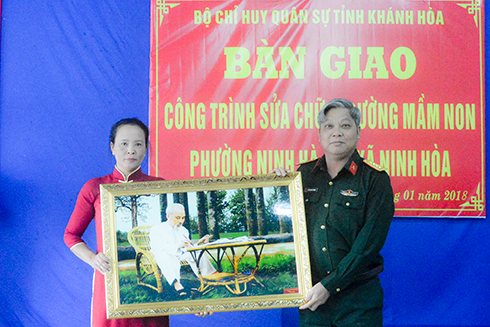 Đại tá Ngô Quang Trung - Chỉ huy trưởng Bộ Chỉ huy Quân sự tỉnh tặng ảnh Bác Hồ cho nhà trường tại lễ bàn giao công trình.                                                                     