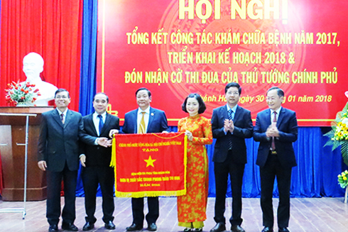 Nguyễn Đắc Tài trao cờ thi đua của Thủ tướng Chính phủ  cho Ban lãnh đạo bệnh viện.