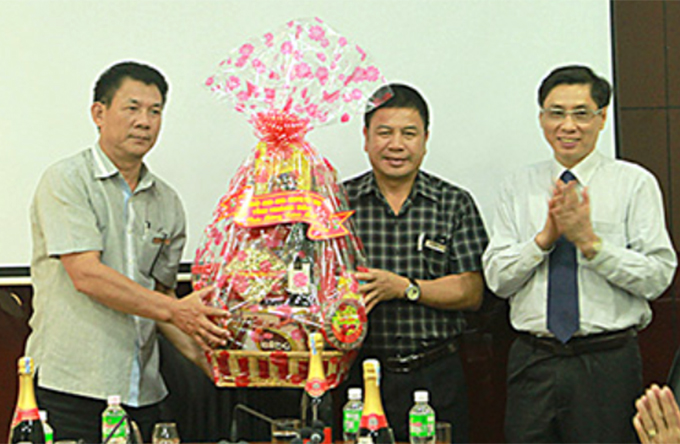 Ông Lê Đức Vinh (bìa trái) tặng quà chúc mừng năm mới đến lãnh đạo Đài Phát thanh và Truyền hình Khánh Hòa.