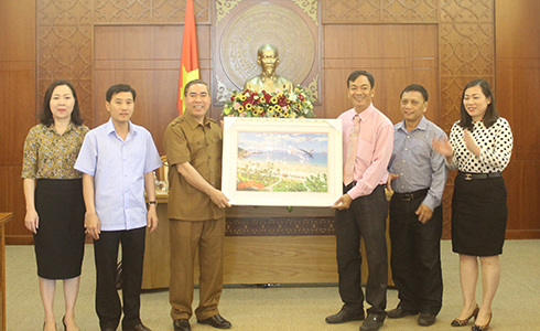 Đại diện Văn phòng UBND tỉnh (bên phải) tặng quà lưu niệm cho đoàn công tác tỉnh Hòa Bình.