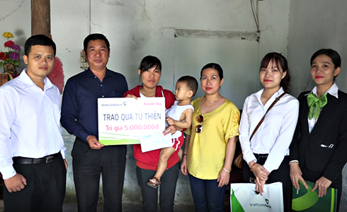 Đại diện Vietcombank Nha Trang và Báo Khánh Hòa trao tiền ủng hộ cho gia đình bé Phan Tuấn Kiệt. 