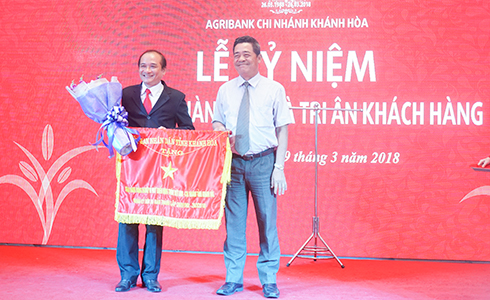 Ông Lê Thanh Quang trao cờ thi đua cho lãnh đạo Agribank Khánh Hòa.
