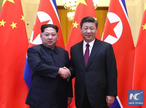 Nhà lãnh đạo Kim Jong-un bắt tay Chủ tịch Tập Cận Bình trong chuyến thăm Trung Quốc. Ảnh: New China.
