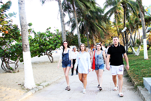 Khách du lịch nước ngoài đi dạo ở công viên bờ biển đường Trần Phú, TP. Nha Trang.