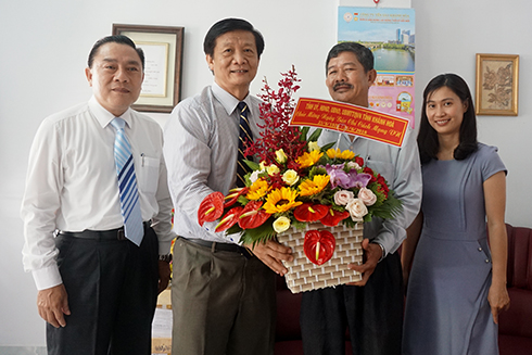 Ông Trần Sơn Hải tặng hoa chúc mừng phóng viên thường trú Báo Nhân dân.