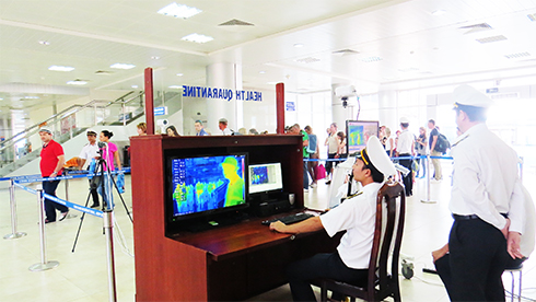 Đo thân nhiệt hành khách tại Cảng hàng không Quốc tế Cam Ranh.