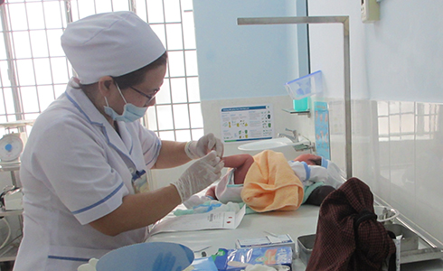 Cán bộ y tế Cam Ranh lấy mẫu máu gót chân trẻ sơ sinh để thực hiện sàng lọc.