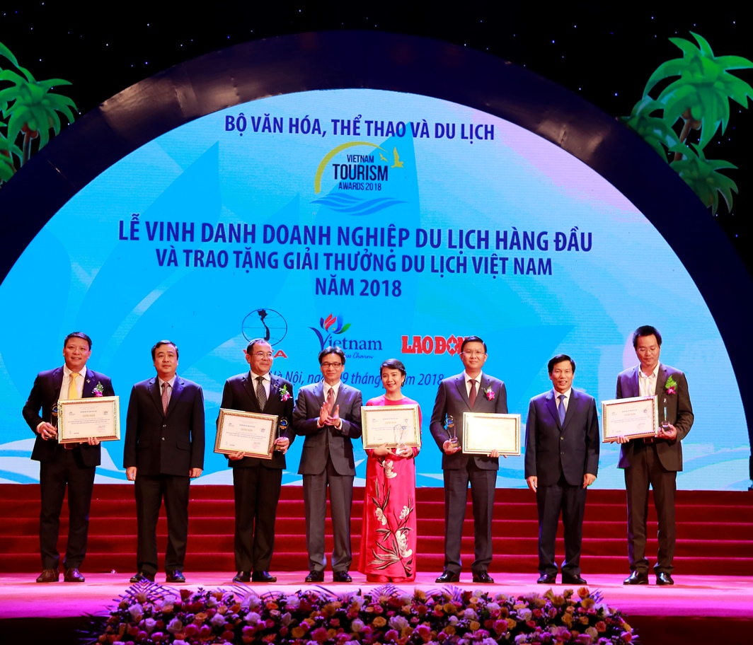  Bà Hoàng Thị Mỹ Hạnh – Phó Tổng Giám đốc Công ty Cổ phần Vinpearl (áo dài đỏ) nhận giải Doanh nghiệp đầu tư và kinh doanh du lịch hàng đầu Việt Nam.