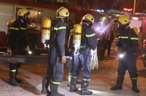 Lính cứu hỏa được trang bị mặt nạ phòng độc, bình ô xi tiếp cận khu vực xảy ra cháy để tìm kiếm nạn nhân.