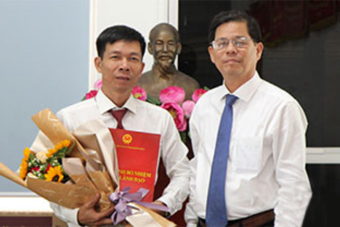 Ông Nguyễn Tấn Tuân trao quyết định và tặng hoa chúc mừng ông Nguyễn Văn Minh.