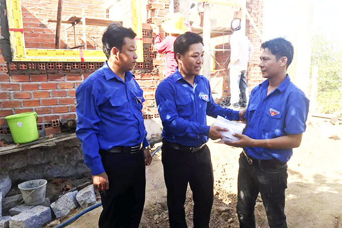 Thường trực Thị đoàn Ninh Hòa trao số tiền hỗ trợ cho anh Huỳnh Ngọc Tư (bìa phải).