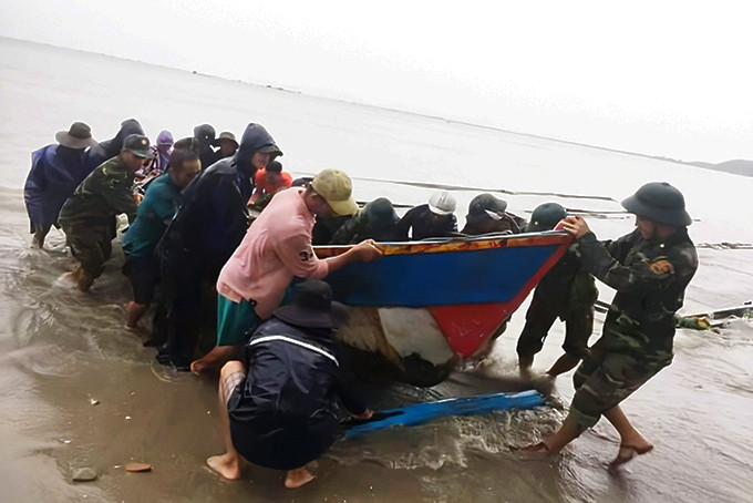 Lực lượng vũ trang huyện Vạn Ninh giúp dân di dời phương tiện để tránh bão. 