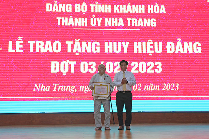 Ông Hồ Văn Mừng trao Huy hiệu 75 năm tuổi Đảng cho đảng viên Nguyễn Xuân Hòa (Đảng bộ phường Vạn Thắng).