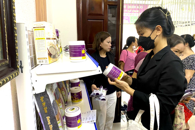 Người dân tìm hiểu sản phẩm gạo tím than tại một điểm giới thiệu sản phẩm ở phường Phước Long.