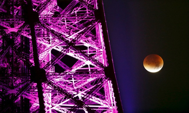 Siêu trăng đỏ ở cạnh tháp Eiffel, Pháp. Ảnh: AP