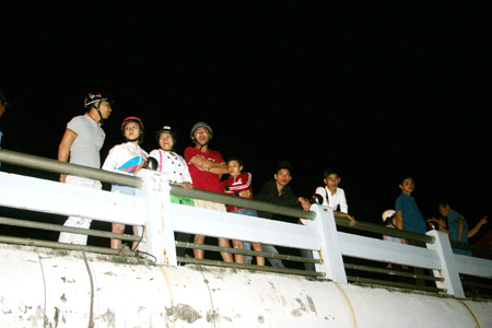 Nhiều người dân đứng trên cầu Bình Tân dõi theo lực lượng chức năng tìm kiếm học sinh mất tích.  