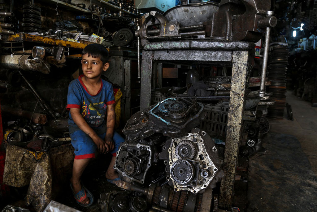 Cậu bé Mustafa (6 tuổi) làm việc cùng với cha tại một khu công nghiệp ở Baghdad, Iraq. (Ảnh: UNICEF)