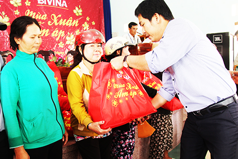Lãnh đạo Công ty TNHH Nhà máy Bia HEINEKEN Việt Nam trao quà cho các hộ dân. 