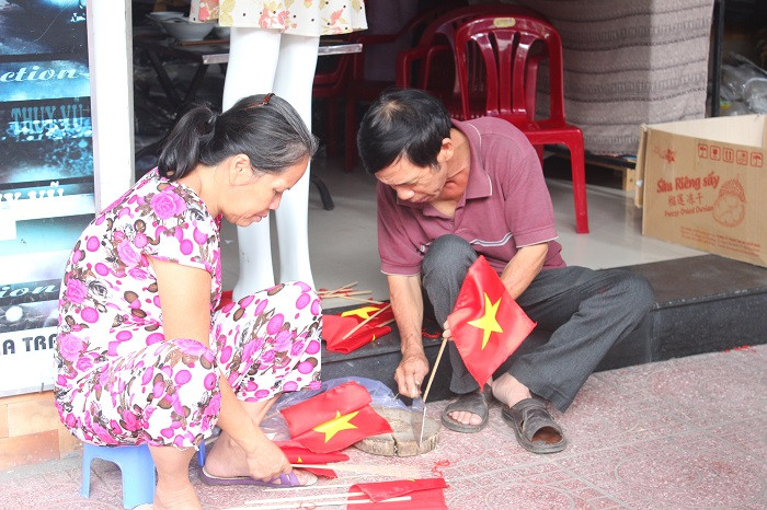 Một cửa hàng trên đường Nguyễn Trãi phải huy động cả người già ra làm cờ tổ quốc để bán cho khách hàng.