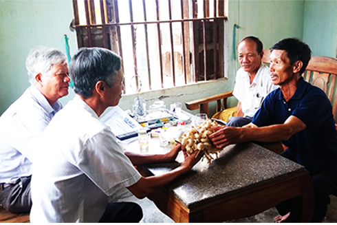Ông Nguyễn Trọng Đáng (bên phải) chia sẻ kinh nghiệm  thu hoạch, bảo quản tỏi khô.
