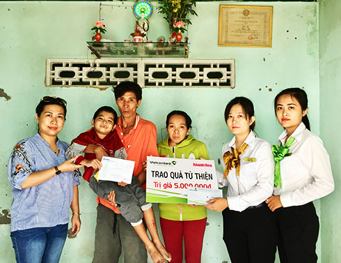 Đại diện Báo Khánh Hòa và Vietcombank Nha Trang trao tiền ủng hộ cho gia đình bé Tấn Sang.