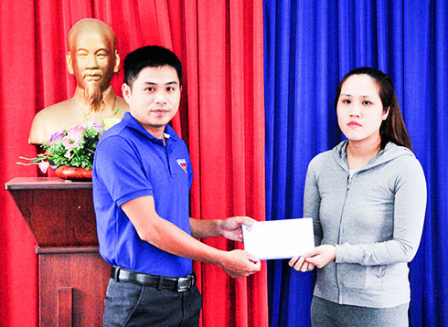 Đại diện Đoàn trường Đại học Khánh Hòa  trao tiền hỗ trợ cho người dân.