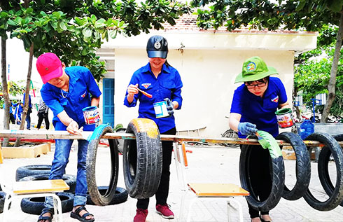 Các tình nguyện viên thi công sân chơi cho học sinh,  thiếu nhi tại xã Cam Thịnh Tây.