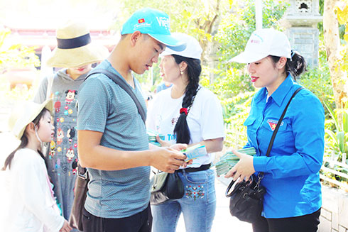 Đoàn viên Chi đoàn Sở Du lịch tuyên truyền và phát Bộ Quy tắc ứng xử văn minh du lịch  cho du khách đến tham quan chùa Long Sơn.