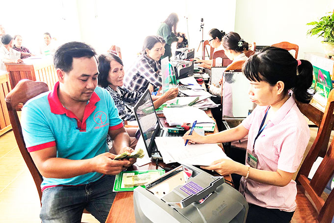 Nhân viên Phòng Giao dịch Ngân hàng Chính sách xã hội huyện Vạn Ninh  giải ngân vốn vay tại xã Vạn Khánh.
