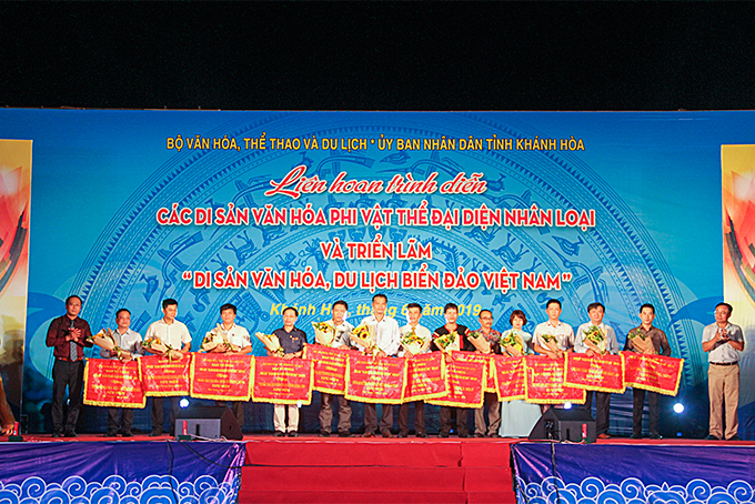 Ban tổ chức trao cờ lưu niệm cho đại diện các đơn vị tham gia Triển lãm di sản văn hóa, du lịch biển đảo Việt Nam. 